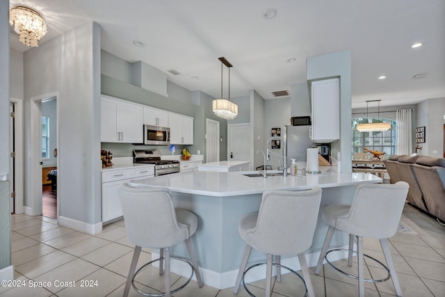 kitchen featuring light tile patterned floors, appliances with stainless steel finishes, a kitchen bar, and a sink