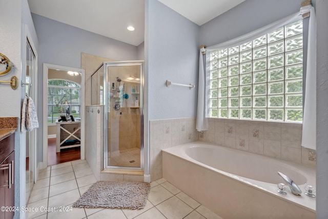 bathroom featuring tile patterned flooring, a bath, vanity, and a stall shower