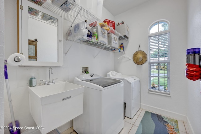 washroom with baseboards, laundry area, light tile patterned flooring, independent washer and dryer, and a sink