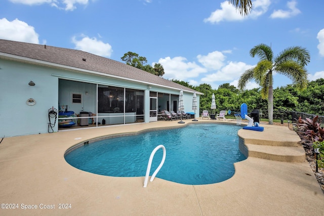 view of pool with a patio area, a fenced in pool, fence, and a sunroom