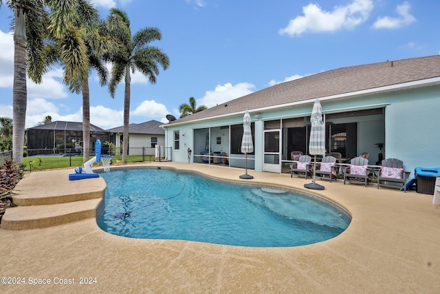 view of pool featuring a patio, fence, a fenced in pool, and a sunroom