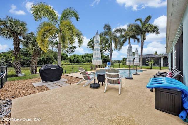 view of patio featuring a lanai, grilling area, a fenced in pool, and fence