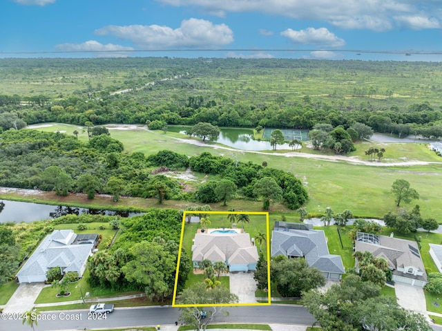 drone / aerial view featuring a wooded view and a water view