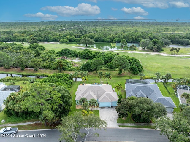 aerial view with a water view and a wooded view