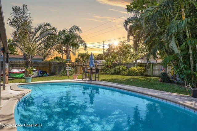 489 Seacrest Ave, Merritt Island, FL 32952 - pool at dusk featuring a yard, a fenced in pool, and a fenced backyard