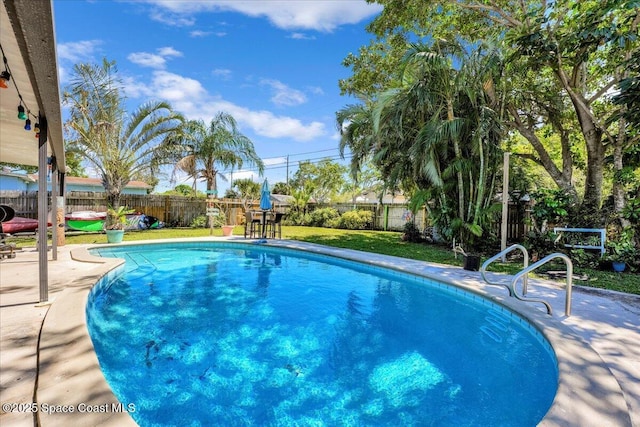 view of swimming pool featuring a patio area, a fenced backyard, a fenced in pool, and a lawn