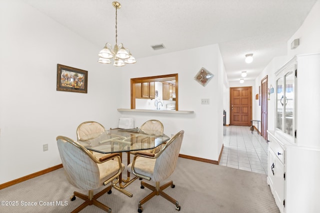 carpeted dining space featuring visible vents, baseboards, a notable chandelier, and tile patterned flooring