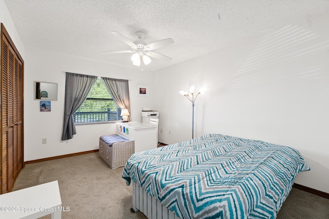 bedroom with a closet, carpet flooring, a textured ceiling, and baseboards