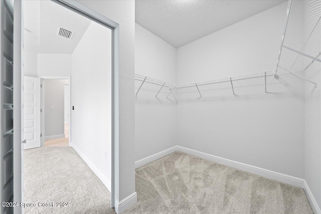 walk in closet with visible vents and carpet flooring