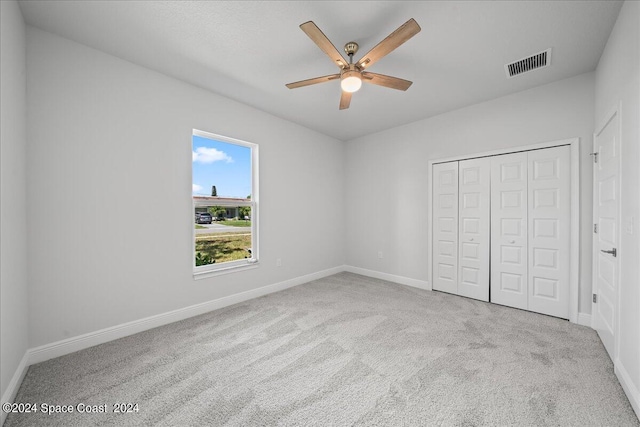 unfurnished bedroom featuring visible vents, baseboards, carpet flooring, a closet, and a ceiling fan