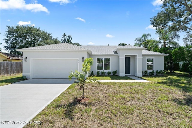 view of front of home featuring stucco siding, driveway, a front lawn, and an attached garage