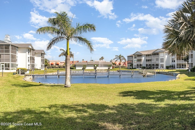 view of property's community featuring a residential view, a yard, and a water view