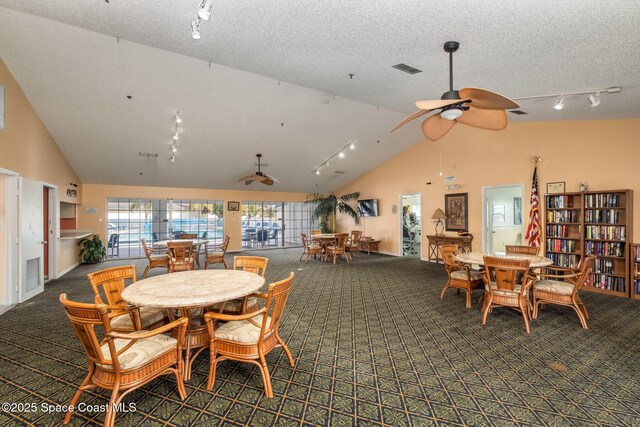 dining room with carpet flooring, rail lighting, a textured ceiling, and visible vents