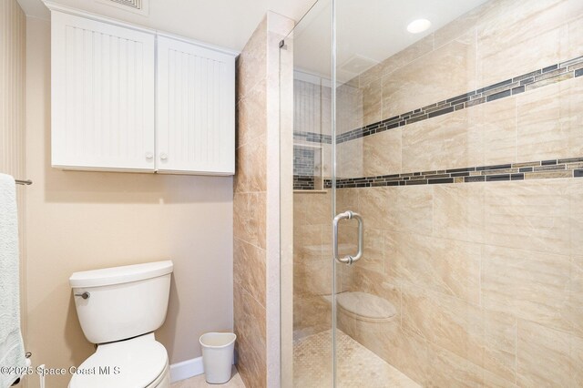 bathroom featuring a shower stall and toilet