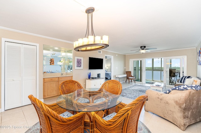 dining space with light tile patterned flooring, ceiling fan with notable chandelier, and ornamental molding