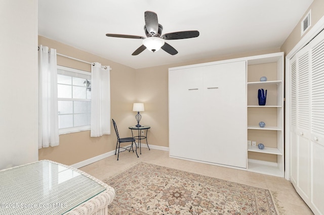 living area with tile patterned flooring, visible vents, baseboards, and ceiling fan