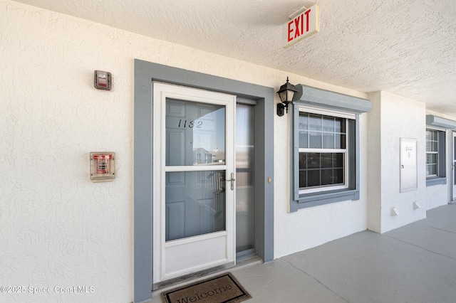 property entrance with stucco siding