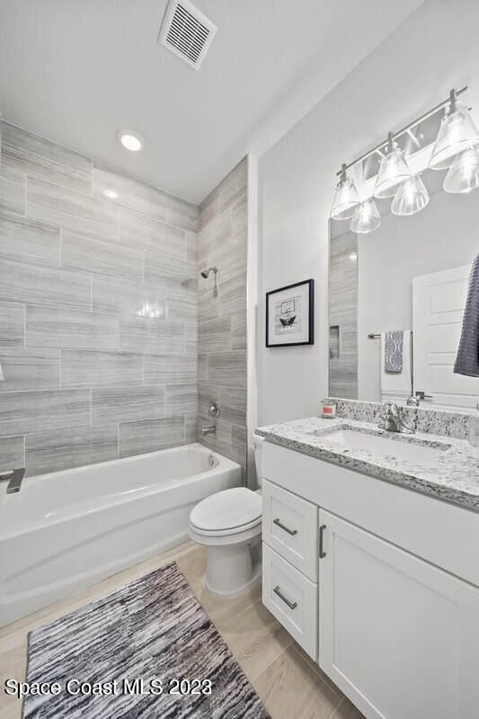 bathroom featuring vanity, shower / tub combination, toilet, and visible vents