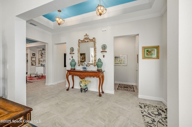 hallway with visible vents, a raised ceiling, baseboards, and ornamental molding