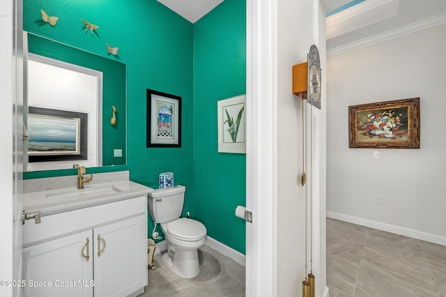 half bathroom with tile patterned floors, toilet, vanity, and baseboards