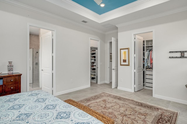 tiled bedroom featuring a spacious closet, visible vents, ornamental molding, a closet, and a raised ceiling