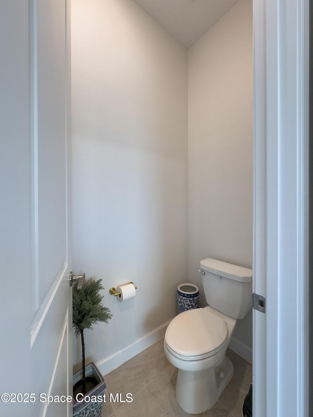 bathroom with tile patterned flooring, toilet, and baseboards