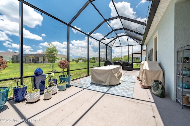 view of patio / terrace featuring glass enclosure, a residential view, and a grill