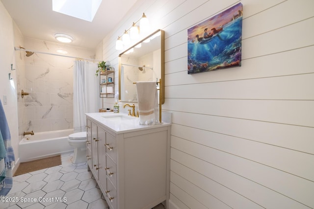 full bathroom with vanity, shower / bathtub combination with curtain, a skylight, tile patterned floors, and toilet