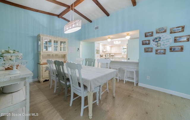 dining space featuring visible vents, beam ceiling, baseboards, and light wood-style flooring