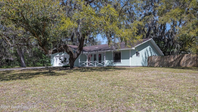 ranch-style house featuring a front lawn and fence