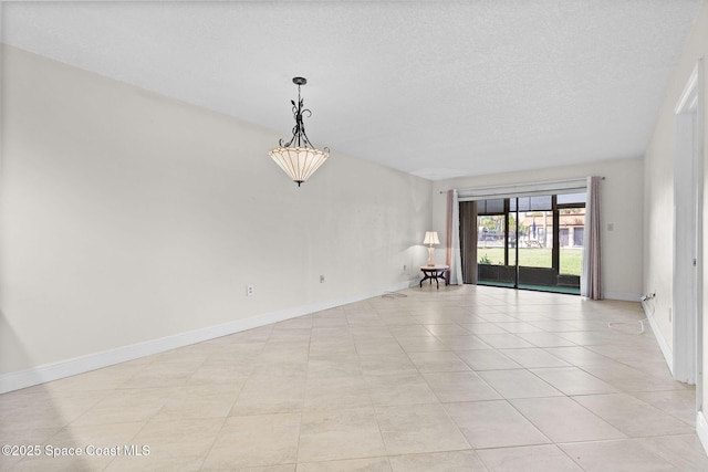 empty room with baseboards and a textured ceiling