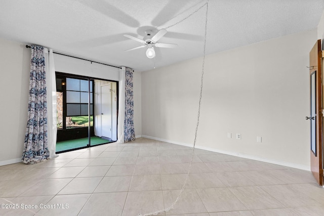 empty room featuring baseboards, light tile patterned floors, a textured ceiling, and ceiling fan