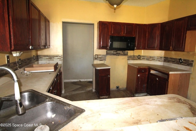 kitchen with a sink, reddish brown cabinets, tasteful backsplash, and black microwave