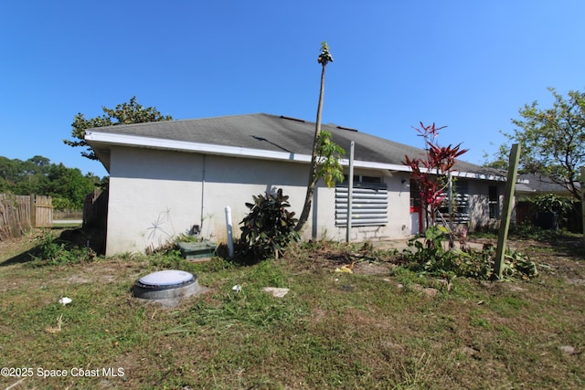 view of side of property featuring fence and stucco siding