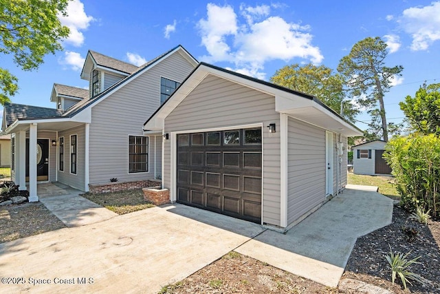 view of side of property with concrete driveway, an attached garage, and a shingled roof