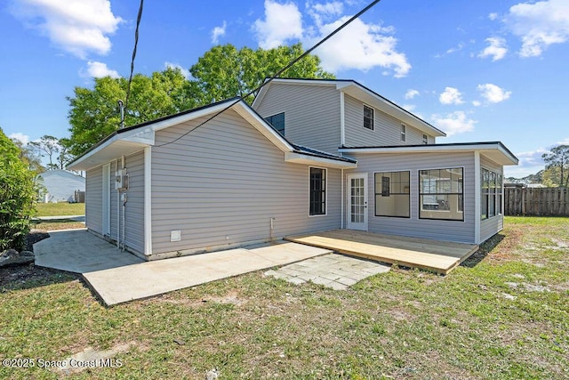 rear view of house featuring a patio area, a lawn, a deck, and fence