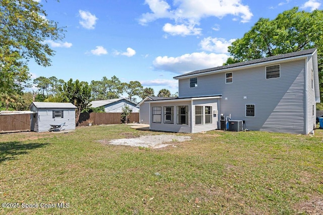 back of property featuring fence, a yard, cooling unit, a storage shed, and an outdoor structure