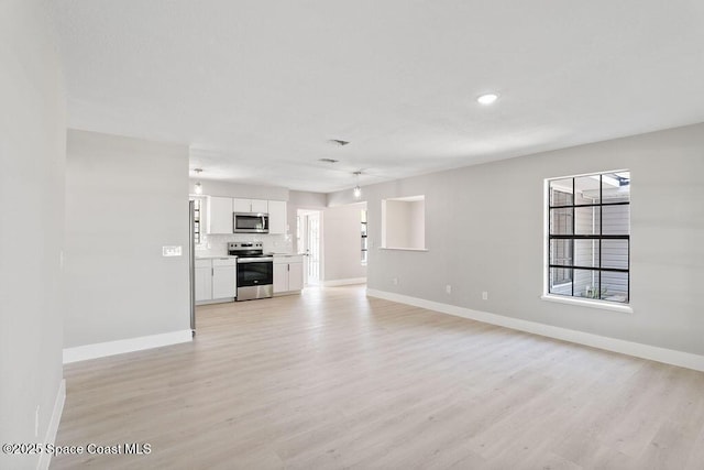 unfurnished living room featuring light wood-type flooring and baseboards