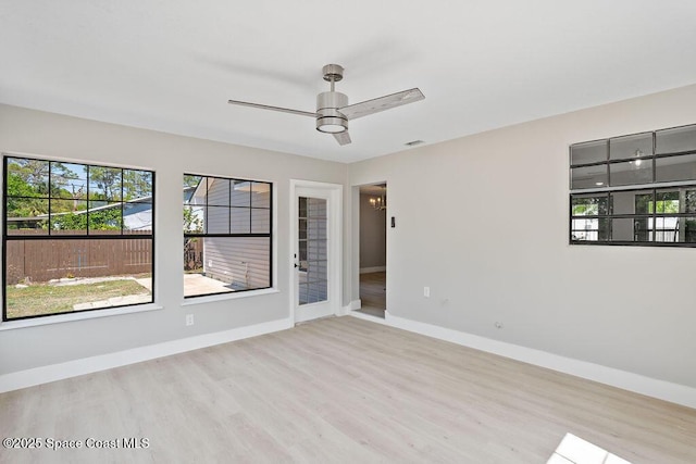 unfurnished room featuring wood finished floors, visible vents, baseboards, and ceiling fan