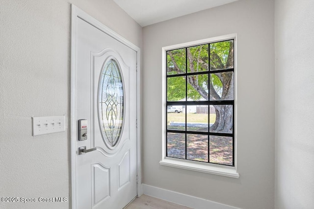 foyer entrance featuring light wood-type flooring and baseboards