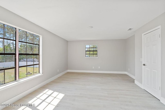 empty room with baseboards and light wood-type flooring