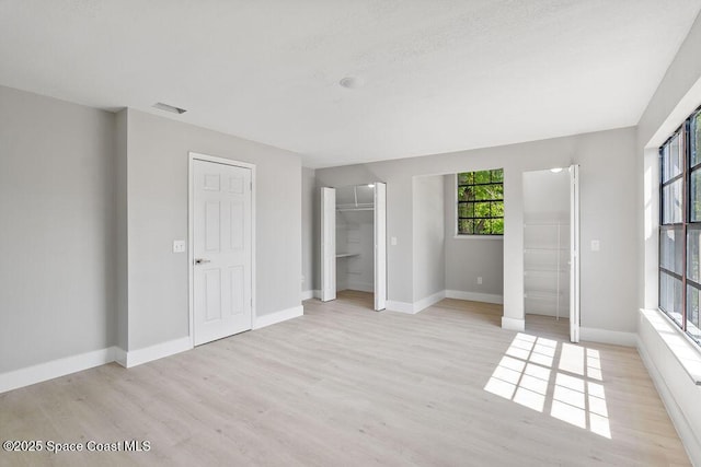 unfurnished bedroom featuring visible vents, baseboards, and light wood-style floors