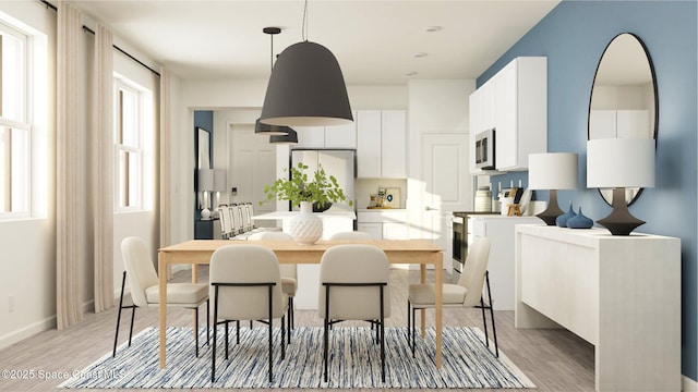 dining area featuring baseboards and light wood-style flooring