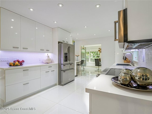 kitchen featuring white cabinetry, modern cabinets, high end fridge, and a sink