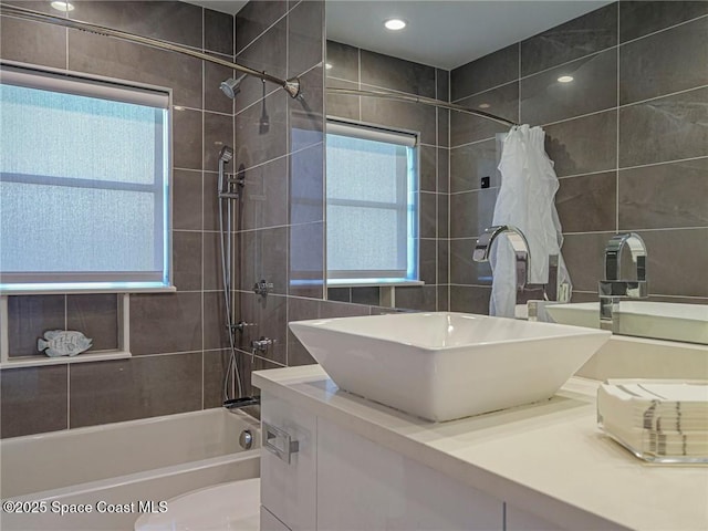 bathroom featuring vanity, tile walls, and washtub / shower combination