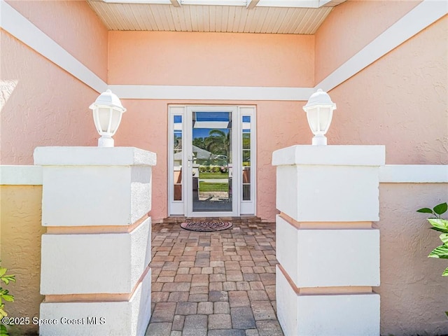 property entrance with stucco siding