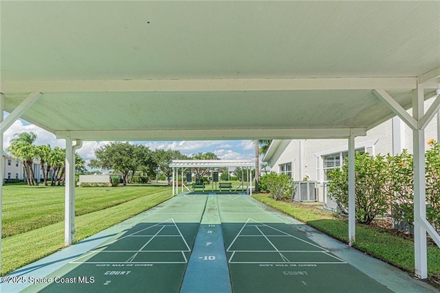 view of property's community featuring shuffleboard and a yard