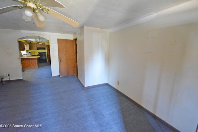 unfurnished room featuring carpet flooring, a ceiling fan, arched walkways, and baseboards