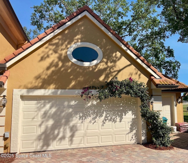 garage with decorative driveway