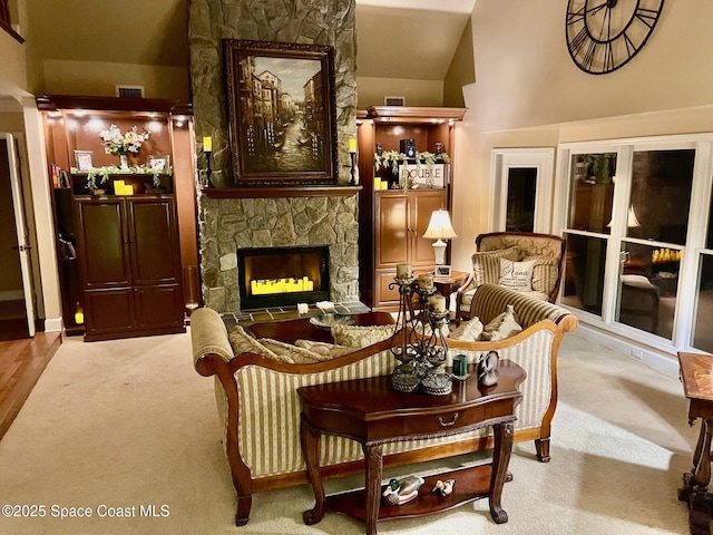 living area featuring carpet flooring, visible vents, and a fireplace